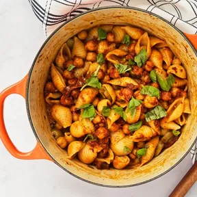 Foto van een pan met vegan pasta puttanesca met kikkererwten